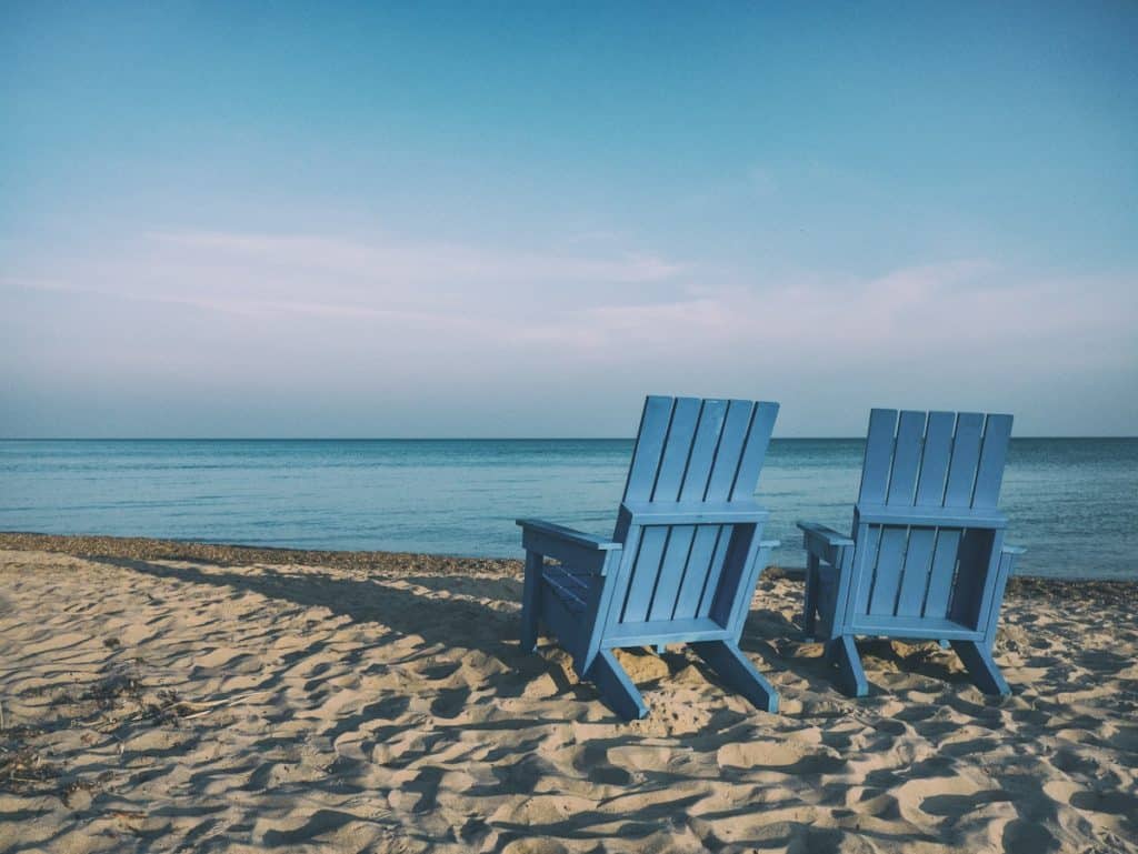 Two blue beach chairs facing a beach. Weekend Getaways: Maximizing Your Next Vacation. hospitality travel