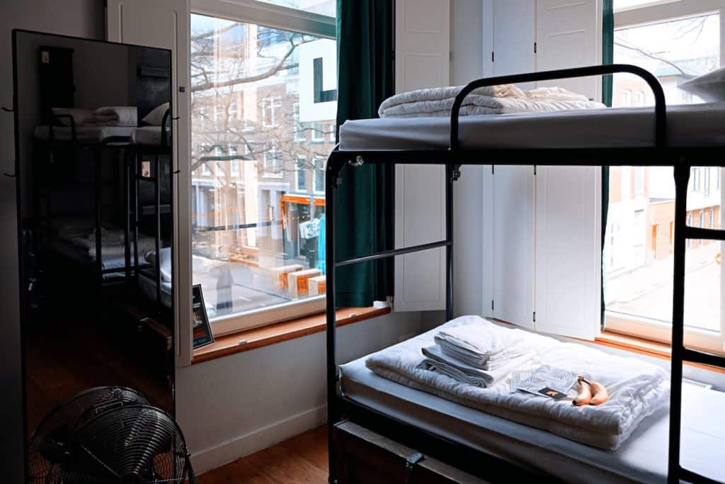 Bunk bed next to a window overlooking the city. Evolution of the Lodging Industry hotel motel inn hospitality